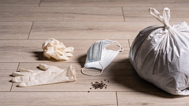 Composition illustrating hantavirus risk, featuring gloves, mask, trash bag, and mouse droppings, emphasizing home safety and rodent contamination.