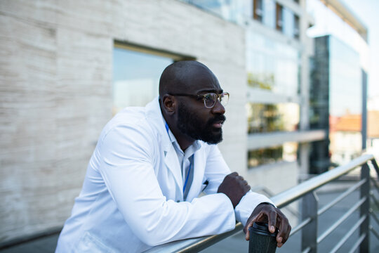 Male doctor taking coffee break on hospital balcony