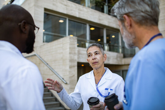 Doctors discussing outside hospital during coffee break