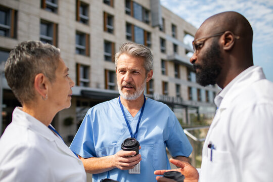 Doctors discussing patient care outside hospital