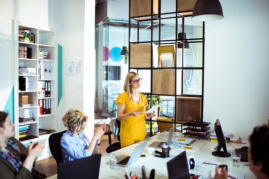Businesswoman leading presentation to team in modern office