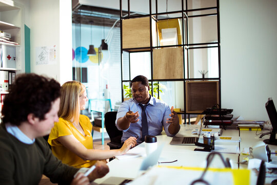 Coworkers discussing project in modern office