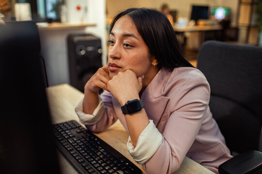 Young professional looking tired at computer in office