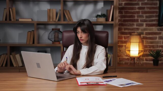 Business woman stares at her computer in disbelief while working.