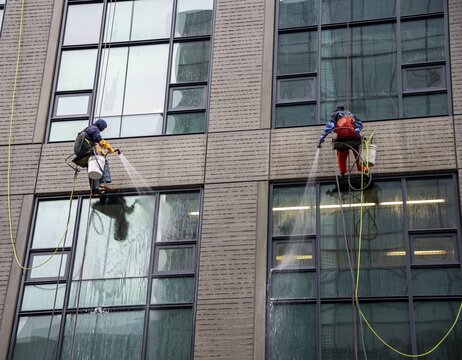 Two window cleaners abseil down a skyscraper, Seattle, Washington, USA