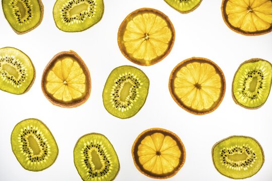 Orange and kiwi in slices, white background, food photography
