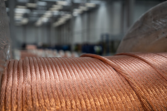 Close up of thick copper wire cable spool in industrial factory warehouse