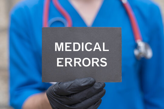 Concept of medical error. Doctor holding black card sees the text MEDICAL ERRORS. Health care errors, malpractice and negligence.