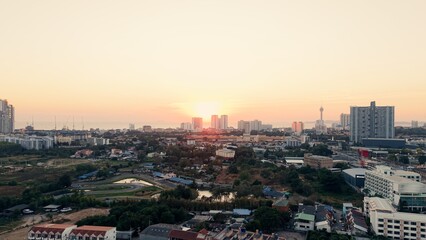 Obraz premium Pattaya city skyline at beautiful sunset creating orange glow over urban landscape