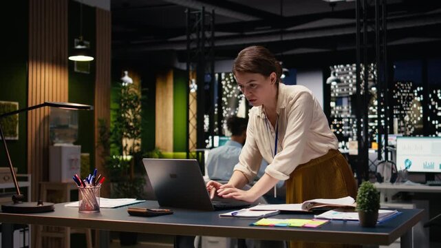 Woman employee in office completing spreadsheets on laptop, organizing agenda and creating action plan. Manager typing on keyboard, researching information and analyzing data online.