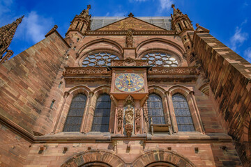 Obraz premium Ancient astronomical clock with Roman numerals and planet symbols displaying days of the week on the facade of Strasbourg Cathedral in France
