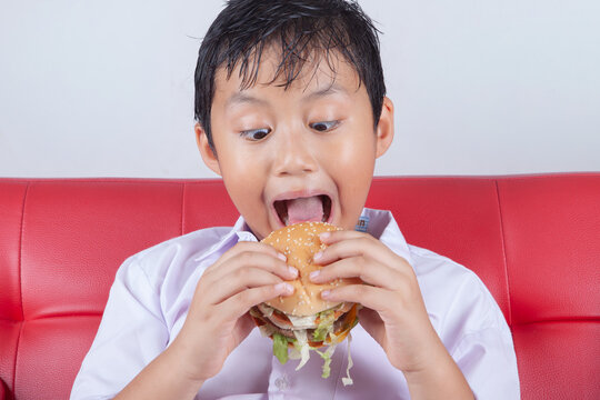 Funny Boy Opening Mouth Wide to Eat a Big Hamburger