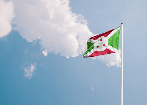 Burundi national flag waving in sky with long mast.