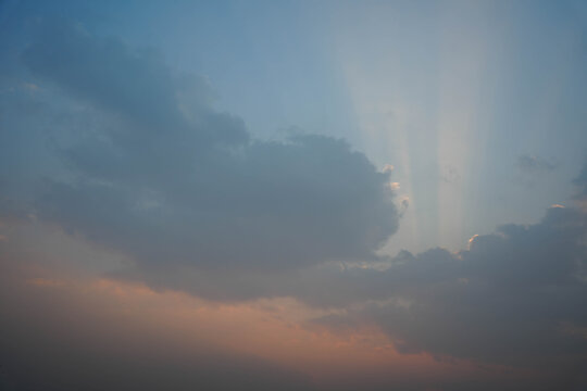 Beautiful sunset sky with dramatic clouds and sun rays breaking through, creating a serene and peaceful atmosphere in the evening light