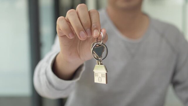 Real estate property investment and home ownership, a person holding a house key.