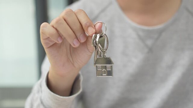 Real estate property investment and home ownership, a person holding a house key.