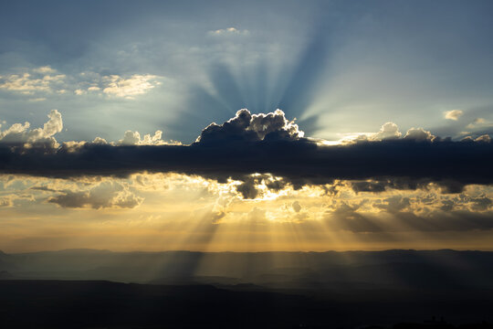 Dramatic Sun Rays Breaking Through Storm Clouds Over Desert Valley
