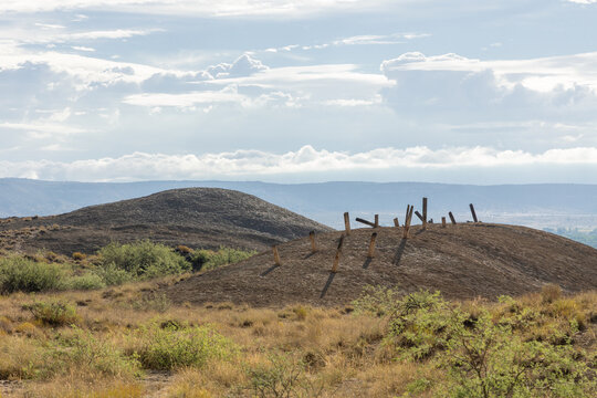 Desert Hills Landscape with Wooden Posts and Dramatic Cloudy Sky