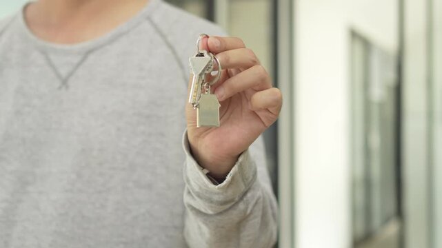 Real estate property investment and home ownership, a person holding a house key.