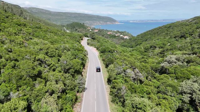 Drone Shot of Car Driving Through Arr&aacute;bida Park with Set&uacute;bal and Troia