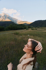 Fototapeta premium Joyful woman outdoors in a meadow, enjoying sunlight, laughter, and a gentle breeze with mountains in the distance, a serene lifestyle moment in nature