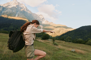 Fototapeta premium Joyful woman outdoors, mid jump with backpack, sunlit meadow and distant mountains, candid lifestyle moment, vibrant natural colors and active spirit in a bright setting