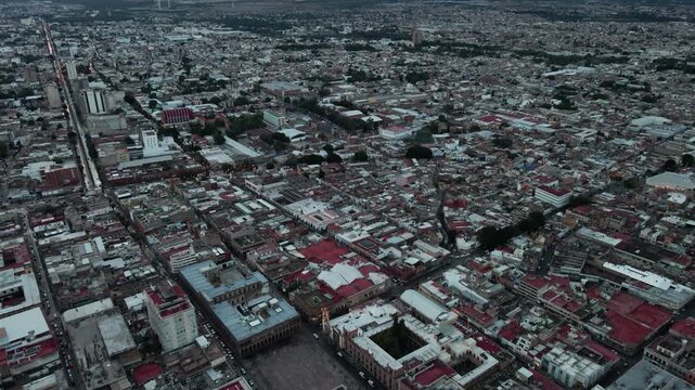 Vista a&eacute;rea de drone del centro hist&oacute;rico de San Luis Potos&iacute; al atardecer con luces urbanas encendi&eacute;ndose.