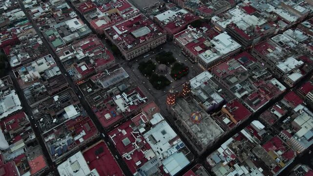 Vista a&eacute;rea de drone del centro hist&oacute;rico de San Luis Potos&iacute; al atardecer con luces urbanas encendi&eacute;ndose.