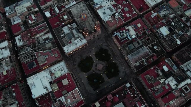 Vista a&eacute;rea de drone del centro hist&oacute;rico de San Luis Potos&iacute; al atardecer con luces urbanas encendi&eacute;ndose.