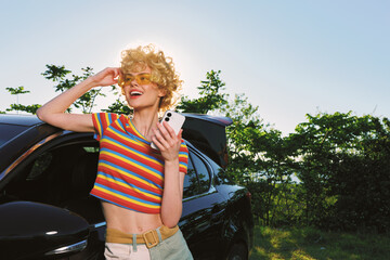Joyful woman outdoors wearing a striped shirt, enjoying sunlight and a gentle breeze, with a retro...