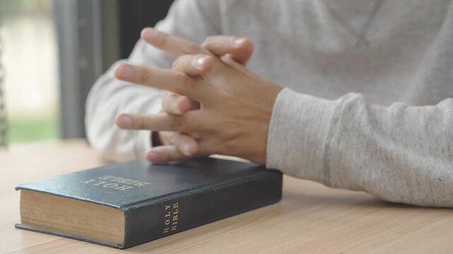 Person reading scripture and praying in a quiet moment of devotion.