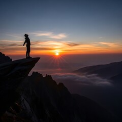 Fototapeta premium A lone figure stands on a dramatic mountain cliff edge, silhouetted against a vibrant sunrise over a misty valley.