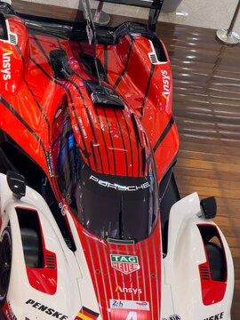 BELO HORIZONTE, MG, BRAZIL, MAY, 10, 2026 A close-up view of a red and white race car model with sponsor logos on a wooden floor