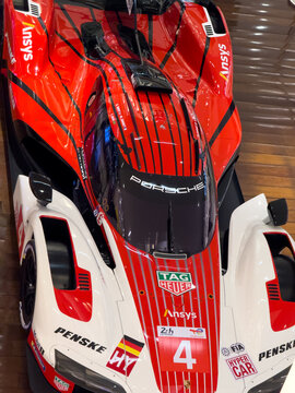 BELO HORIZONTE, MG, BRAZIL, MAY, 10, 2026 A close-up view of a red and white Porsche race car with sponsor logos on a wooden surface