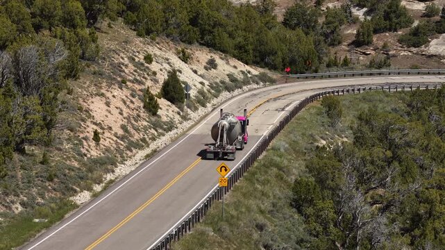 Aerial zoom shot of semi truck on winding mountain pass US Highway 191 in Vernal Utah