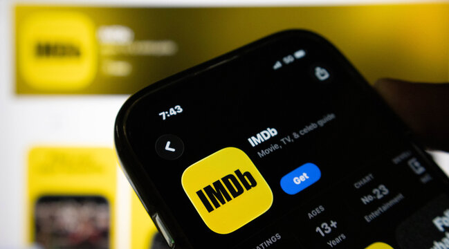 Closeup of a smartphone screen displaying the imdb app store page with the app icon, rating, and ranking information visible