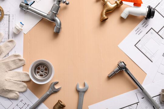 Frame made from set of plumber's items and house plans on beige background