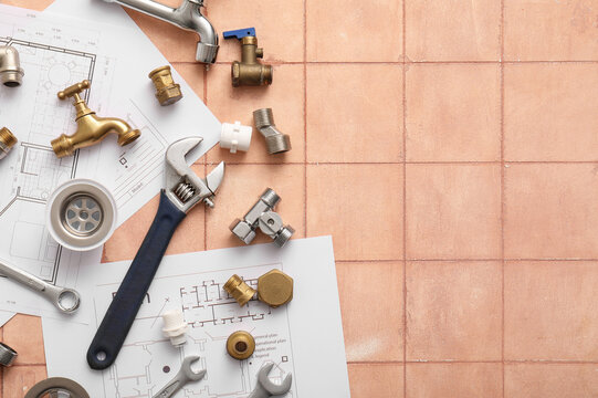 Set of plumber's items and house plans on beige tiled background