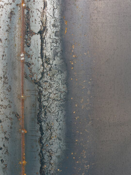 Dark Gritty Industrial Metal Surface with Rust and Weld Lines