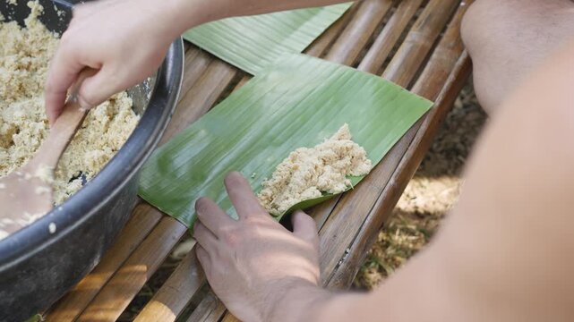 Wrapping Cassava Suman with Coconut Leaf Strips in Traditional Filipino Cooking