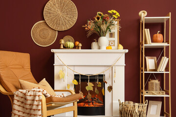 Fototapeta premium Interior of living room with fireplace, armchair and autumn flowers in vase