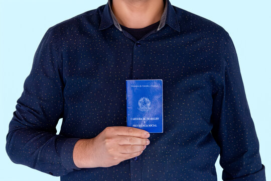  Brazilian Man Holding CTPS Work Card on Blue Background, Employment and Labor Rights Concept