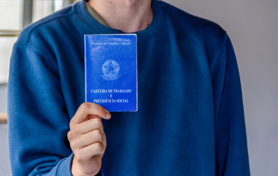  Young Brazilian Man Holding CTPS Work Card, Employment and Labor Rights Concept