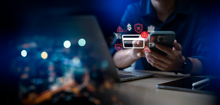 Online payment fraud detection and cybersecurity threat alert concept. Man using smartphone and laptop with credit card, warning icon, and digital security interface for mobile banking safety