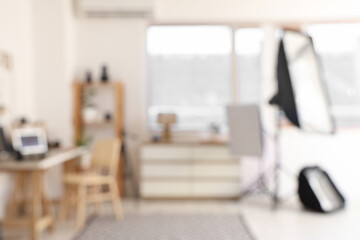 Fototapeta premium Blurred view of office with photographer's workplace, shelf unit and professional equipment