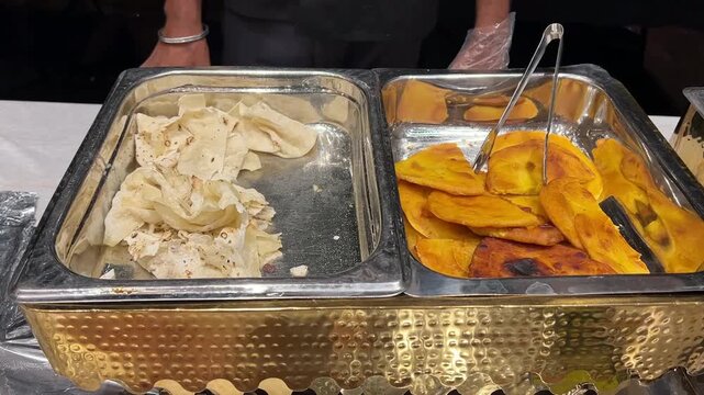 A premium buffet presentation of freshly baked rumali roti and flaky layered lachha paratha at a luxury marriage reception banquet in India.