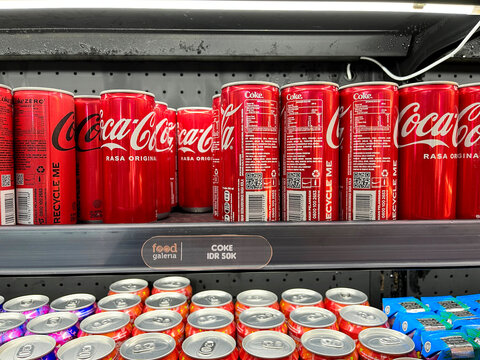 Coca-Cola classic red cans and Coke Zero displayed on a refrigerated shelf at Food Galeria near Lacoste in Ngurah Rai Bali Airport - Bali, Indonesia, April 04, 2023