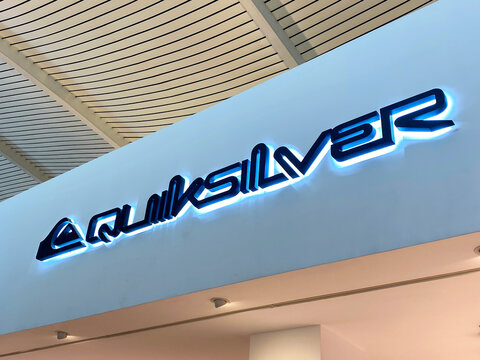 Quiksilver and Lacoste retail storefront signage at Ngurah Rai International Airport departure terminal featuring luxury fashion brands - Bali, Indonesia, April 04, 2023