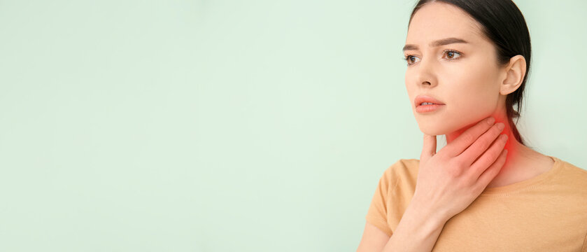 Young woman with thyroid gland problem on color background