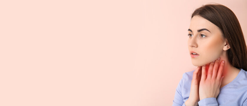 Young woman checking thyroid gland on color background